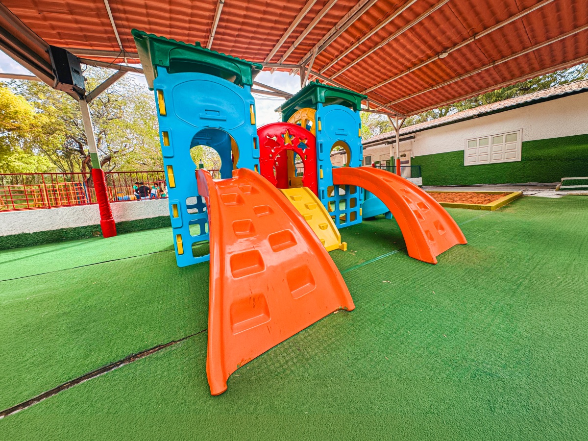 Playground coberto com brinquedos e piso emborrachado